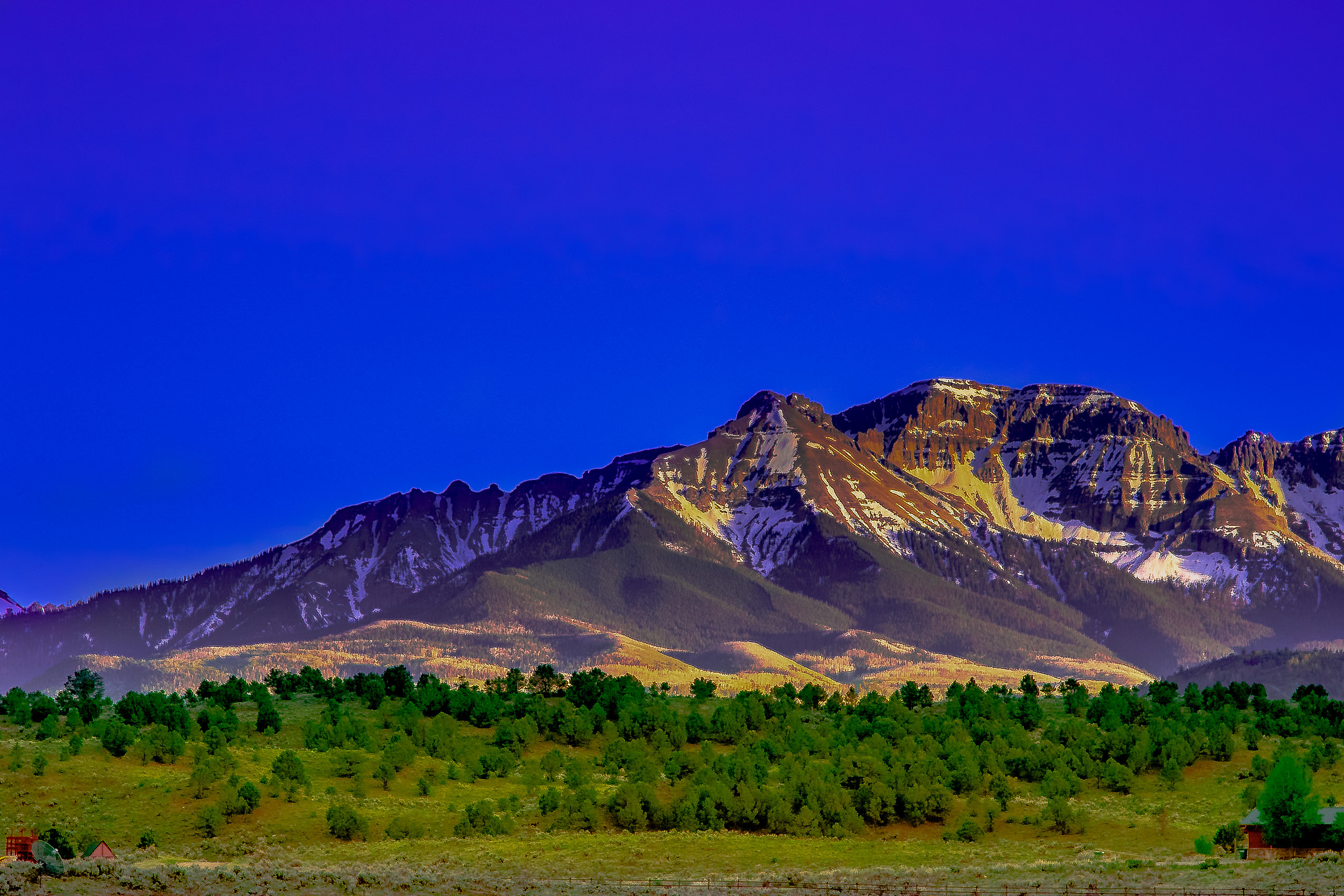 San Juan peaks at blue hour — deep purple sky over snow-streaked ridgelines