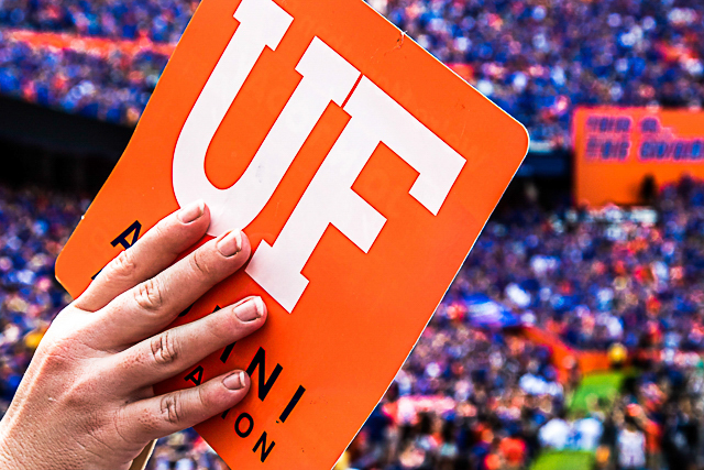 Go Gators — fan holding a UF sign in a packed stadium at the University of Florida