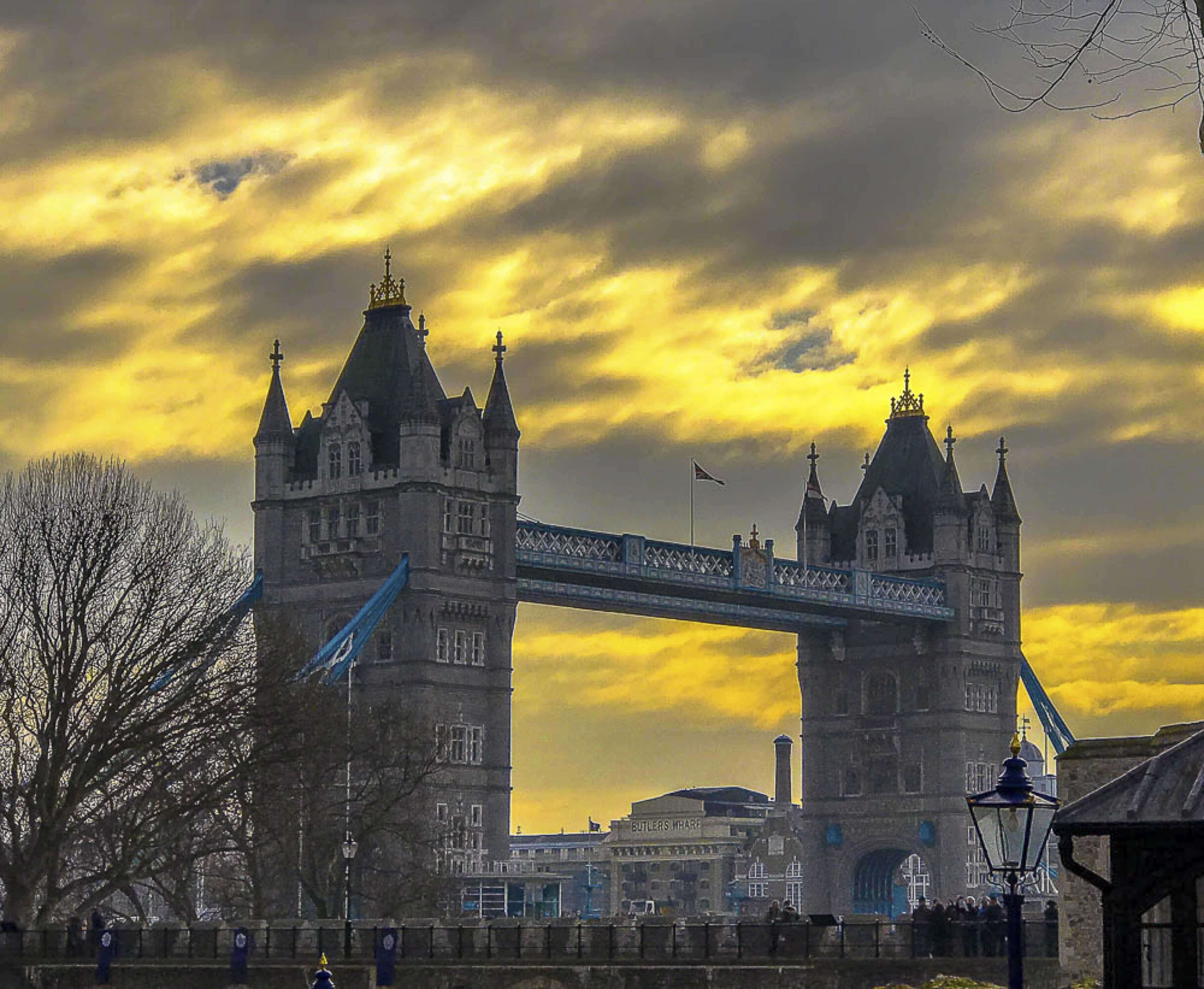 Tower Bridge at golden hour under dramatic storm clouds
