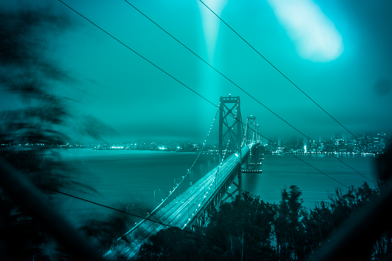 Bay Bridge eastern span at night — cable-stayed tower reflected in the Bay