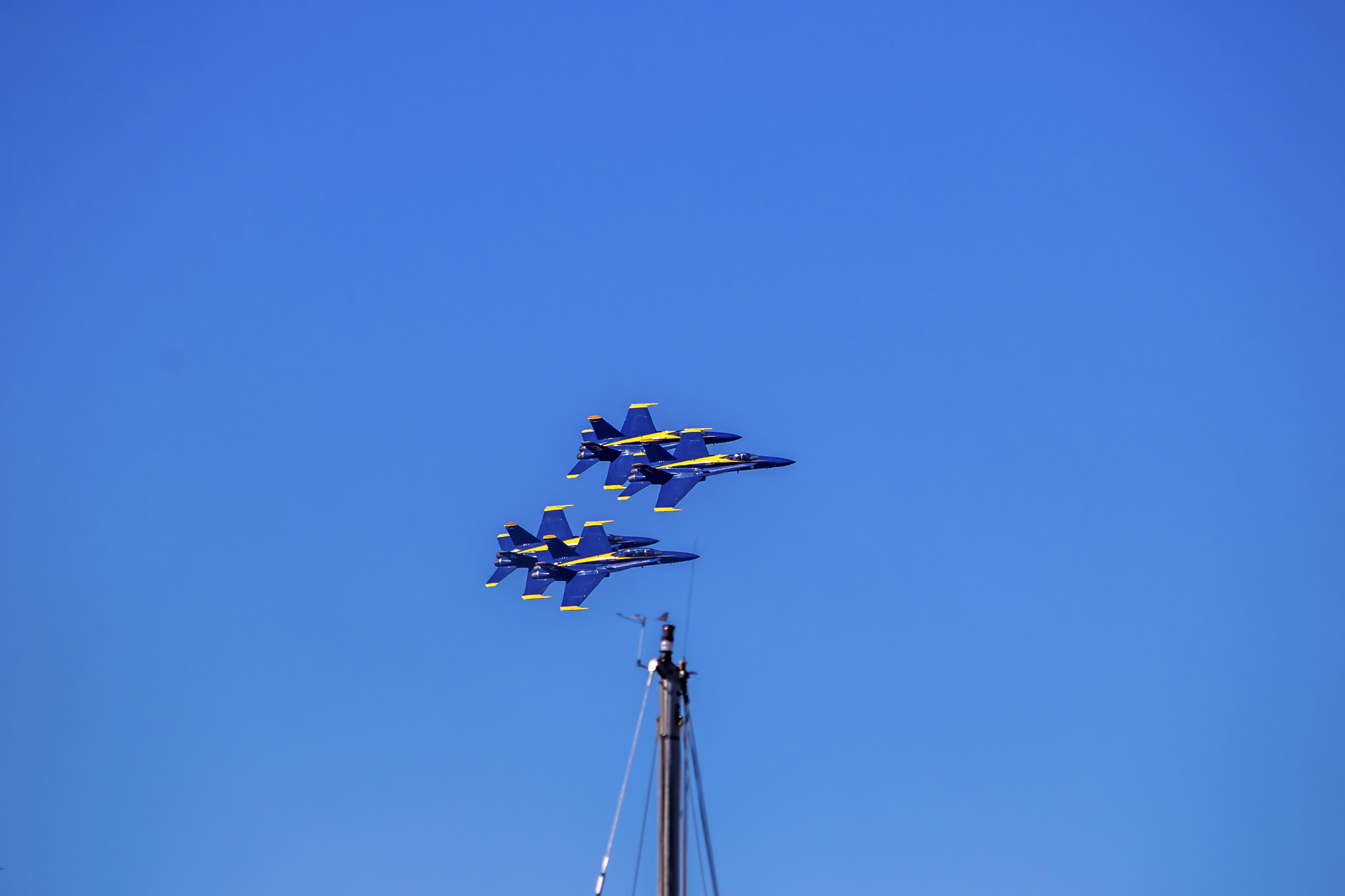Blue Angels climbing near-vertical after a low pass over the waterfront