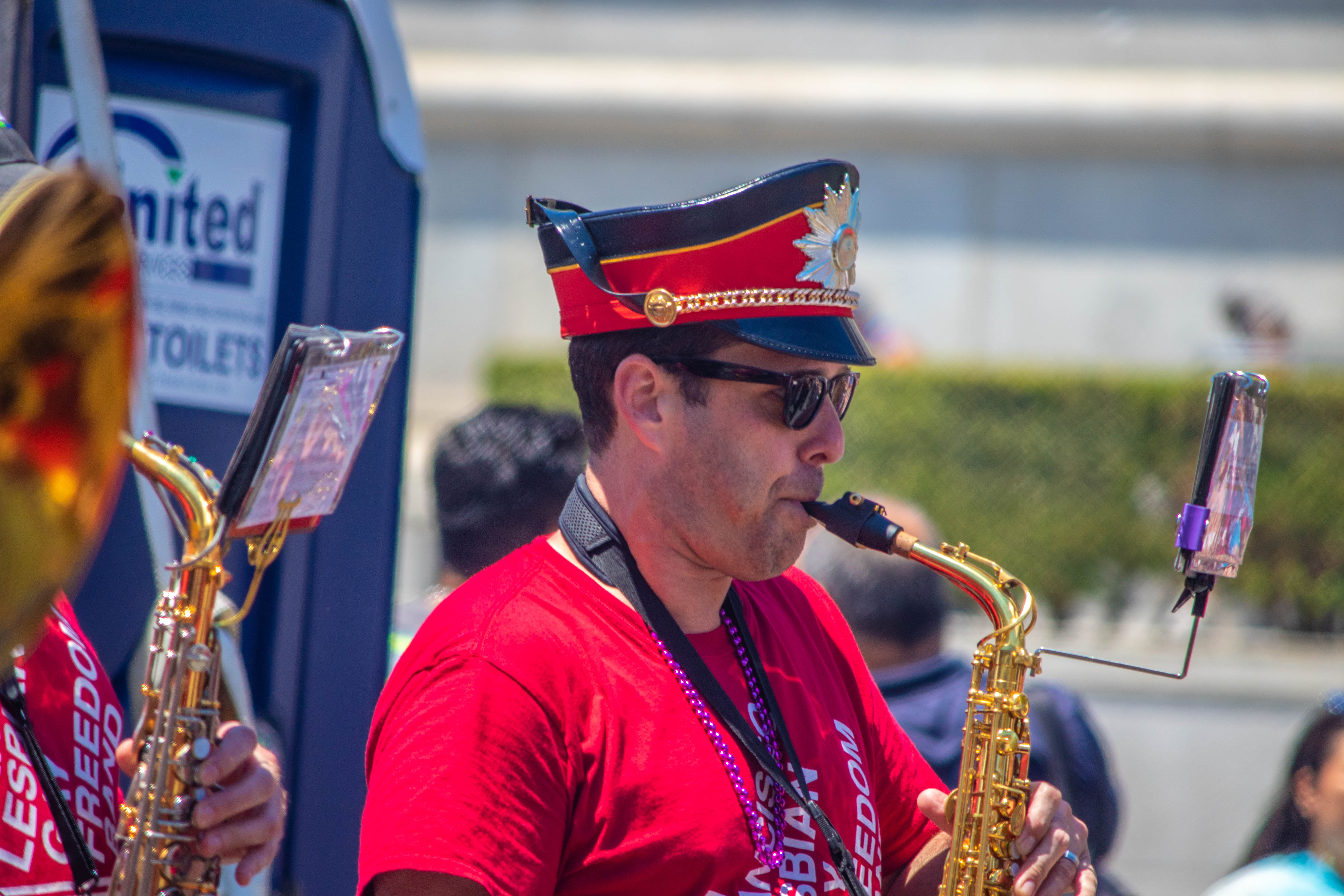 Freedom Band saxophonist — red uniform, marching cap, and sunglasses