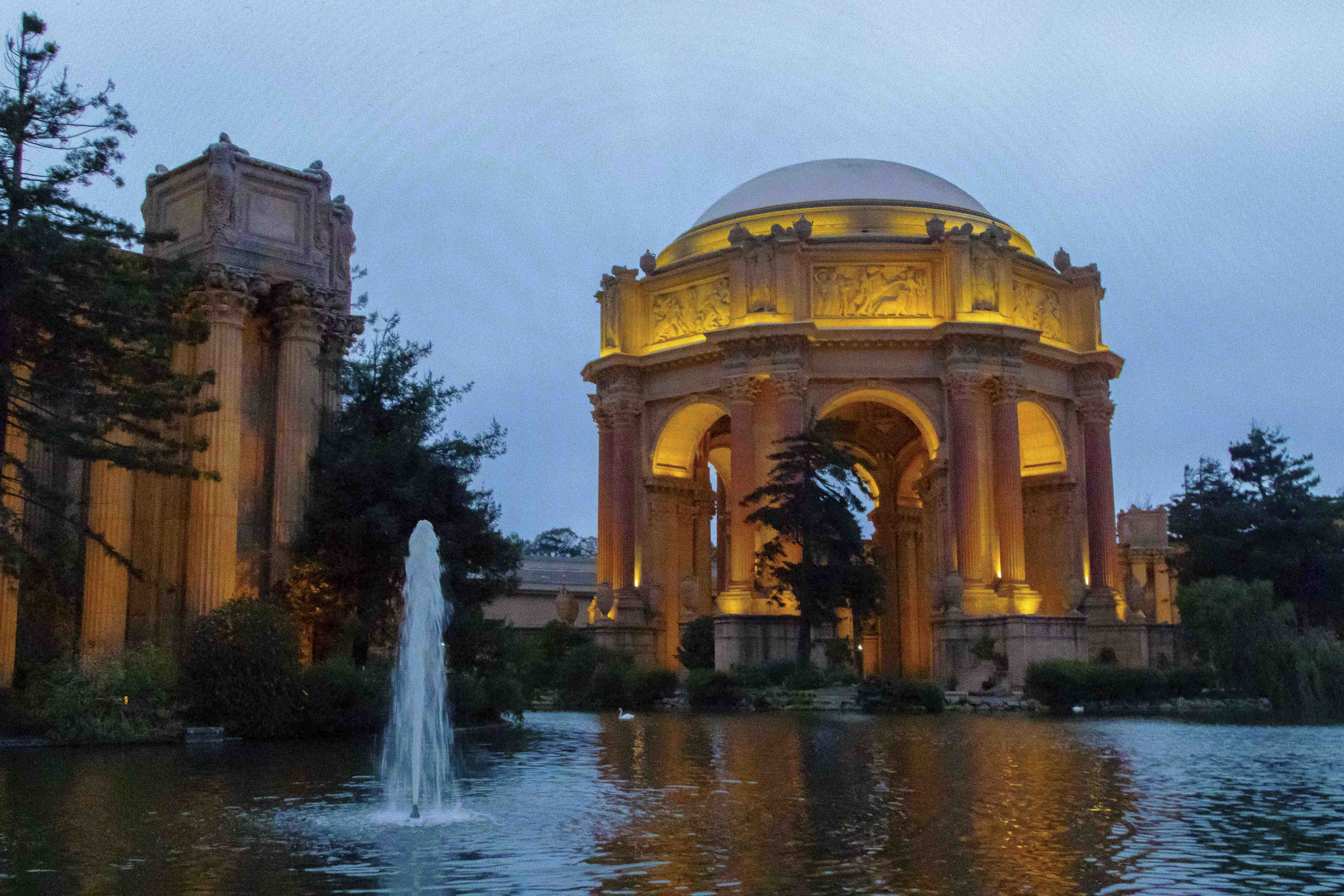 Palace of Fine Arts lit at night with the lagoon fountain