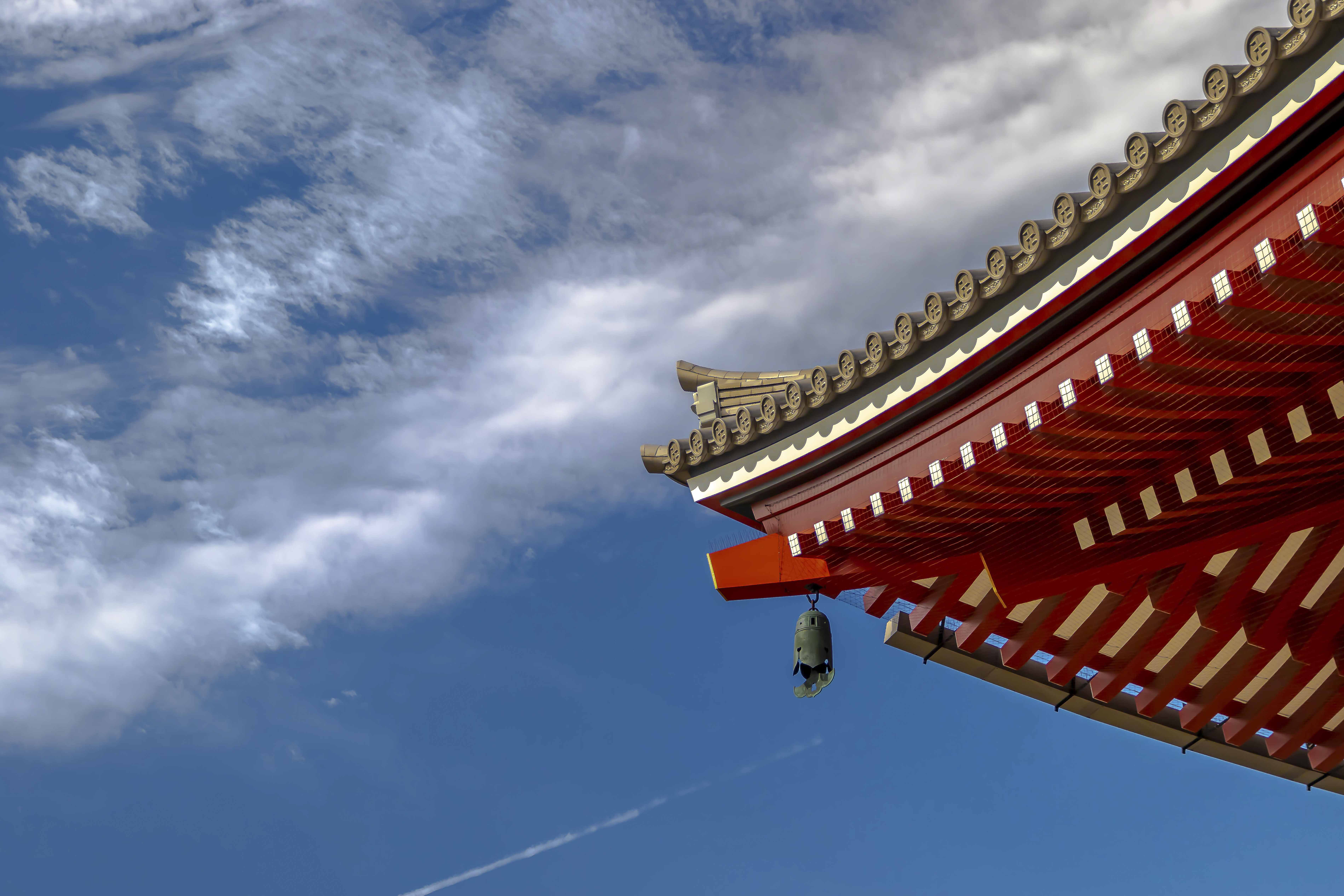 Senso-ji roofline and temple bell against blue sky