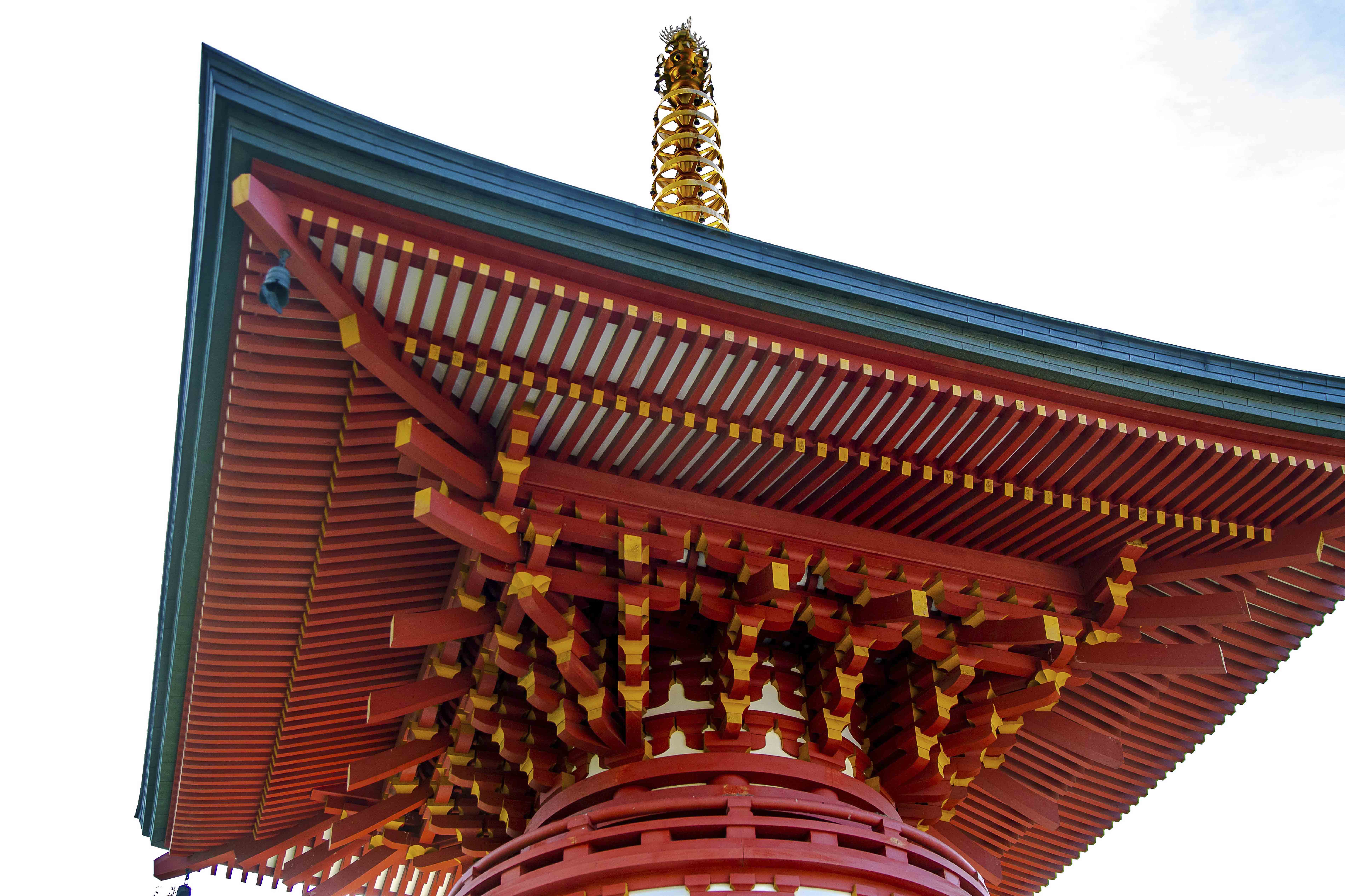 Pagoda eave detail — red lacquer and gold finial