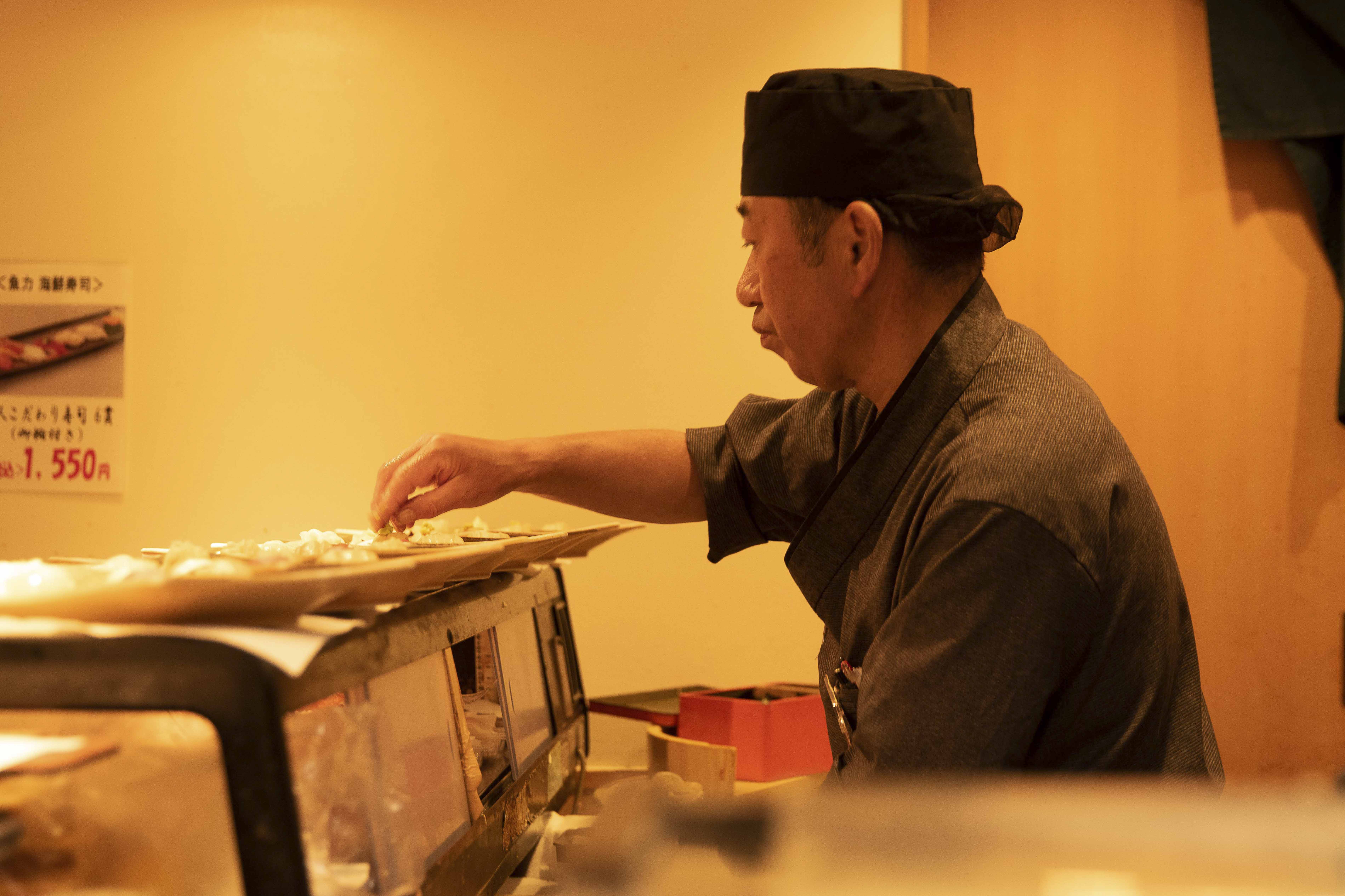 Sushi chef at work behind the counter